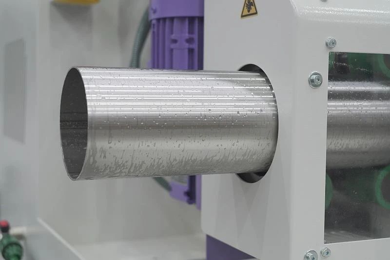 Dvouhlavá pásová bruska na trubky NS MLW100 2Z - obroušená trubka na výstupu ze stroje