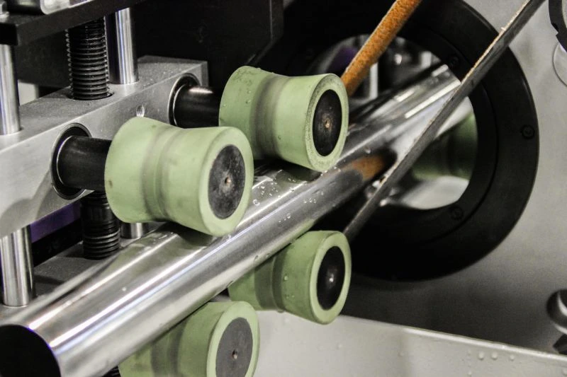 NS MLW100 3Z - Pásová bruska na trubky - posuv trubky skrz obráběcí jednotku s brusnými pásy